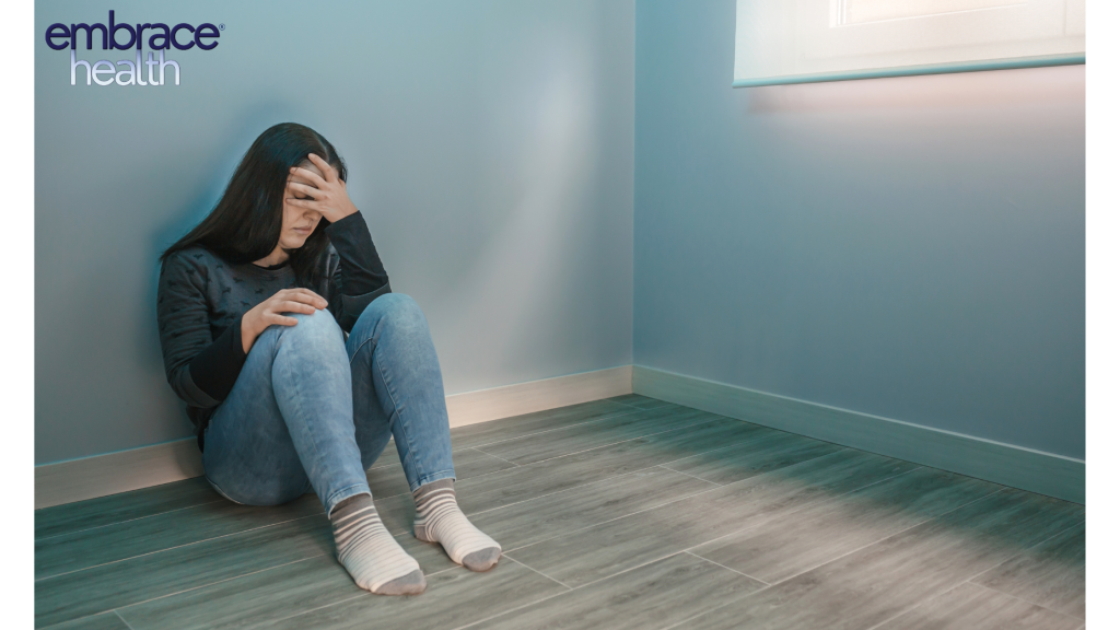 Burnout 1 A woman sitting on the floor with her head in her hands, showing signs of burnout, fatigue, and the mental health challenges many adults face in balancing work, life, and personal well-being.